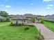 Single-story home with a landscaped lawn and paver driveway at 5159 Greens Dr, Lady Lake, FL 32159