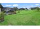 Large backyard with lush lawn and partial view of pool at 5159 Greens Dr, Lady Lake, FL 32159