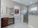 Bathroom with granite vanity, walk-in shower, and laundry access at 5159 Greens Dr, Lady Lake, FL 32159