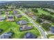 Aerial view of a neighborhood with a house featuring a pool and green space at 5159 Greens Dr, Lady Lake, FL 32159