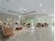Open living room with tile floors, coffered ceiling, and access to pool and lanai at 5159 Greens Dr, Lady Lake, FL 32159