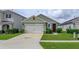 House exterior with a two-car garage and landscaping at 3654 Caspian St, Leesburg, FL 34748