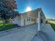 Tan single-wide manufactured home with carport and mature landscaping at 1660 Elkhart Cir, Tavares, FL 32778