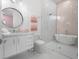 Spa-like bathroom featuring a soaking tub, glass shower, and pink tile at 15617 Pendio Dr, Bella Collina, FL 34756
