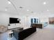 Spacious living area with a plush sectional sofa, a large TV, and modern decor at 15617 Pendio Dr, Bella Collina, FL 34756