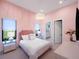 Bedroom with pink walls, a comfortable bed, and a chandelier at 15617 Pendio Dr, Bella Collina, FL 34756