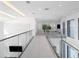 Bright hallway with glass railings overlooking the main living space at 15617 Pendio Dr, Bella Collina, FL 34756