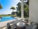 Relaxing poolside patio with seating and tranquil water views at 15617 Pendio Dr, Bella Collina, FL 34756