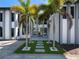 Modern home entry with gray and white exterior, palm trees, and pavers at 15617 Pendio Dr, Bella Collina, FL 34756