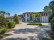 Modern home with gray and white exterior, paver driveway, and palm trees at 15617 Pendio Dr, Bella Collina, FL 34756