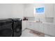 Bright laundry room with washer, dryer, and ample cabinet space at 15617 Pendio Dr, Bella Collina, FL 34756