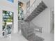 Modern gray floating staircase with glass railings at 15617 Pendio Dr, Bella Collina, FL 34756