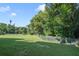 Large grassy backyard with privacy fence and mature trees at 151 S Clayton St, Mount Dora, FL 32757