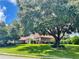 House with red tile roof partially obscured by a large tree at 39331 Treeline Dr, Lady Lake, FL 32159