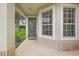Inviting front porch with a green door and large windows at 5206 Fantasy Way, Leesburg, FL 34748