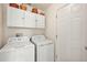 Functional laundry room with washer, dryer, and overhead cabinets at 5206 Fantasy Way, Leesburg, FL 34748