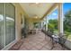 Spacious screened porch with patio furniture and lush landscaping views at 5500 Belle Terre Dr, Leesburg, FL 34748