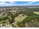 Aerial view of community featuring lush green landscape, golf course, and residential homes at 5500 Belle Terre Dr, Leesburg, FL 34748