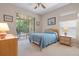 Bright bedroom featuring a queen bed and access to a private patio at 5500 Belle Terre Dr, Leesburg, FL 34748