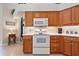 Kitchen with wood cabinets, white appliances, and ample counter space at 5500 Belle Terre Dr, Leesburg, FL 34748