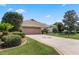 Single-story house with attached garage and well-maintained lawn at 5500 Belle Terre Dr, Leesburg, FL 34748