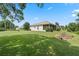 Landscaped backyard with lush lawn and partial home view at 5500 Belle Terre Dr, Leesburg, FL 34748