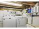 Unfinished basement laundry area with washer, dryer, and shelving at 151 S Clayton St, Mount Dora, FL 32757