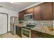 Modern kitchen with granite countertops and stainless steel appliances at 3450 Landing Vw, Tavares, FL 32778
