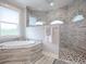 Primary bathroom with soaking tub, walk-in shower, and a large window at 3457 Lake Diane Rd, Tavares, FL 32778