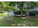 Backyard view of the house, screened porch, and detached shed at 104 Fruitwood Ave, Eustis, FL 32726