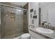 Modern bathroom with a walk-in shower, pebble floor, and updated vanity at 24126 Plymouth Hollow Cir, Sorrento, FL 32776