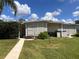 Rear view of the house with a walkway and grassy yard at 34323 Island Dr, Leesburg, FL 34788