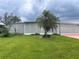 Single-story home exterior with screened lanai and lawn at 34323 Island Dr, Leesburg, FL 34788