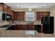 Modern kitchen with dark wood cabinets and granite countertops at 326 Silver Maple Rd, Groveland, FL 34736