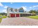 Farmhouse style home with metal roof, red doors, and a brick driveway at 39400 French Rd, Lady Lake, FL 32159