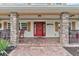 Charming front porch with red rocking chairs and brick flooring at 39400 French Rd, Lady Lake, FL 32159