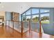 Bright upper hallway with hardwood floors, stone fireplace, and large windows at 39400 French Rd, Lady Lake, FL 32159