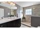 Bathroom with walk-in shower, vanity with dark brown cabinets, and a large mirror at 39400 French Rd, Lady Lake, FL 32159