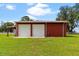 Large red barn with two garage doors at 39400 French Rd, Lady Lake, FL 32159