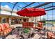 Enclosed patio with pool, comfortable seating, and an umbrella at 39400 French Rd, Lady Lake, FL 32159