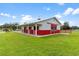 Red and white barn with multiple stalls and large doors at 39400 French Rd, Lady Lake, FL 32159
