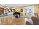 Spacious living area featuring a grand piano, kitchen view, and French doors at 39400 French Rd, Lady Lake, FL 32159