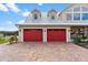 Two-car garage with red doors and brick driveway at 39400 French Rd, Lady Lake, FL 32159