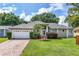 Charming house exterior with a two-car garage and manicured lawn at 27637 Lisa Dr, Tavares, FL 32778