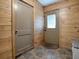 Laundry room with wood walls, tiled floor, and exterior access at 4988 County Road 155, Wildwood, FL 34785