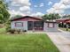 Charming ranch home with a screened porch and manicured lawn at 4988 County Road 155, Wildwood, FL 34785