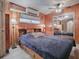 Bedroom with wood paneled walls, a large bed, and ample light at 4988 County Road 155, Wildwood, FL 34785