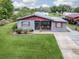 Gray house with red roof, screened porch, and landscaped yard at 4988 County Road 155, Wildwood, FL 34785