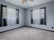 Simple bedroom with neutral decor and two windows at 4988 County Road 155, Wildwood, FL 34785