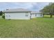 Green grassy backyard with a view of the house's back at 36641 Tropical Wind Ln, Grand Island, FL 32735